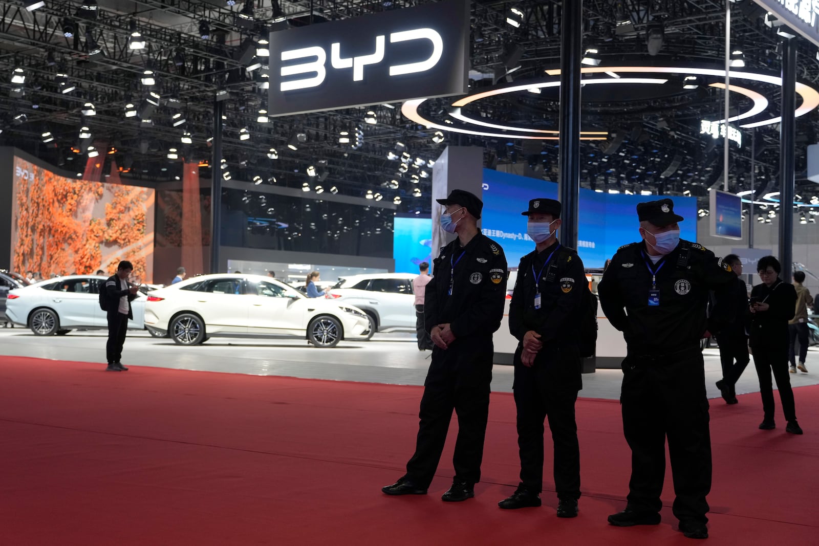 Security personnel on duty stand near the BYD booth during the Shanghai auto show, April 23, 2025. (AP Photo/Ng Han Guan)