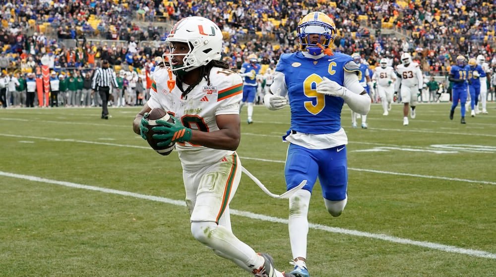 Miami wide receiver Malachi Toney (10) scores in front of Pittsburgh linebacker Kyle Louis (9) during the first half of an NCAA college football game, Saturday, Nov. 29, 2025, in Pittsburgh. (AP Photo/Matt Freed)
