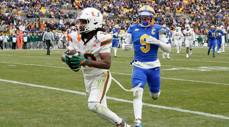 Miami wide receiver Malachi Toney (10) scores in front of Pittsburgh linebacker Kyle Louis (9) during the first half of an NCAA college football game, Saturday, Nov. 29, 2025, in Pittsburgh. (AP Photo/Matt Freed)
