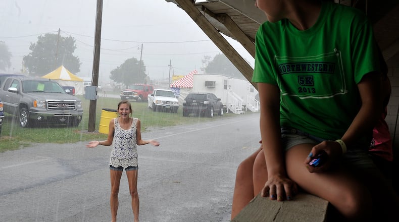 Elly Grimm, 14, plays in the rain Friday at the Clark County Fair as her friends watch her from a window in a dry barn. Bill Lackey/Staff