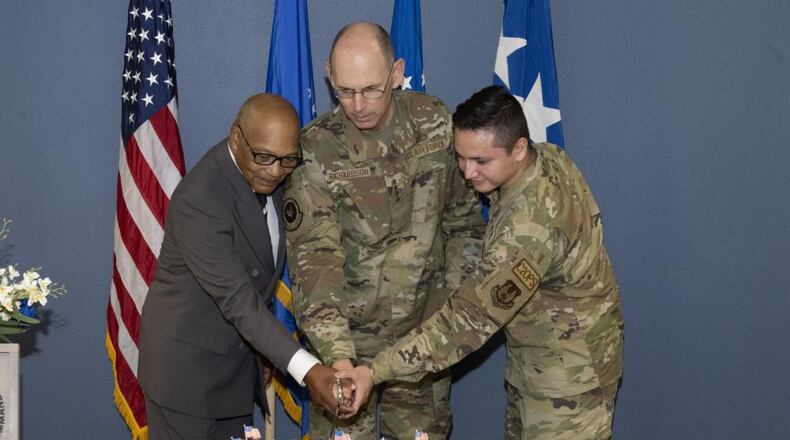 Gen. Duke Richardson, commander of Air Force Materiel Command, cuts the cake to commemorate the 30th anniversary of AFMC. The ceremony marking the history and heritage took place at Wright-Patterson Air Force Base July 11. Assisting the general (from left) is Wright-Patterson AFB’s longest serving civilian, Fred Bennett, and WPAFB’s most junior Airman, Airman 1st Class Robert Hernandez. (U.S. Air Force photo by Jerry Bynum)