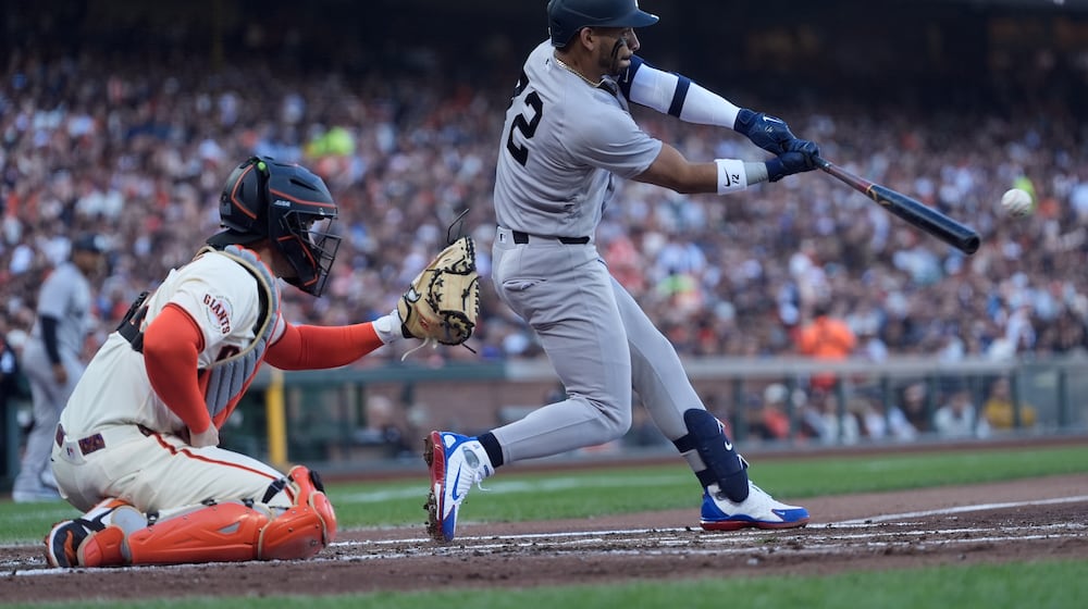 New York Yankees' José Caballero, right, hits an RBI double in front of San Francisco Giants catcher Patrick Bailey, left, during the second inning of a baseball game in San Francisco, Wednesday, March 25, 2026. (AP Photo/Jeff Chiu)