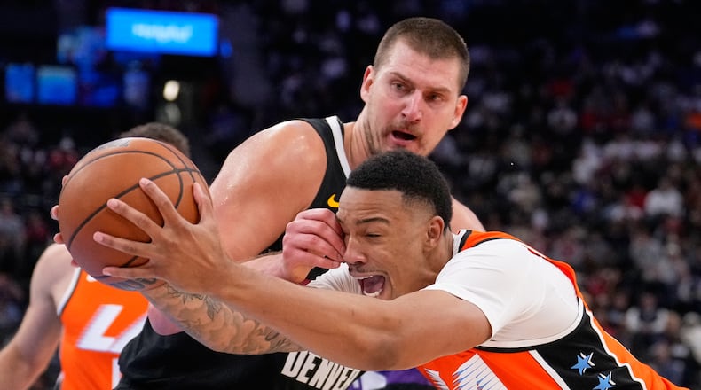 Los Angeles Clippers guard Jordan Miller, right, drives past Denver Nuggets center Nikola Jokic during the second half of an NBA basketball game Wednesday, Nov. 12, 2025, in Inglewood, Calif. (AP Photo/Mark J. Terrill)