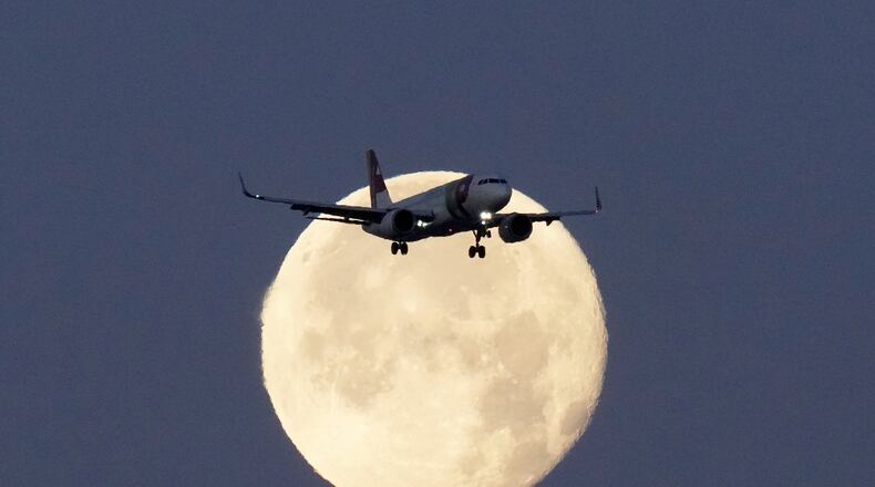 FILE - A TAP Air Portugal Airbus A320 is silhouetted against the setting moon while approaching for landing in Lisbon, Portugal, June 23, 2024. (AP Photo/Armando Franca, File)