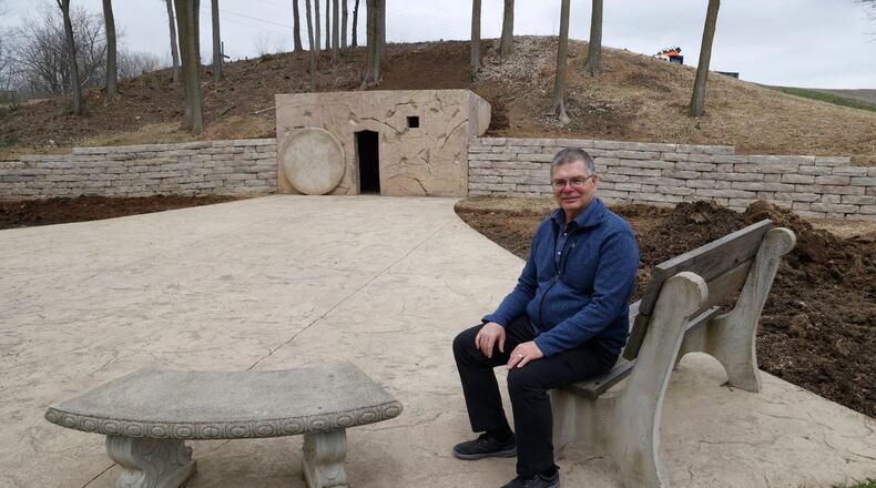 Pastor Brian Miller, of the Berea Bible Church, sits outside the Jesus tomb re-creation outside the church Tuesday, April 4, 2023. Berea Bible Church is developing the area around the tomb to make it a public park where people can come and enjoy the surroundings. BILL LACKEY/STAFF