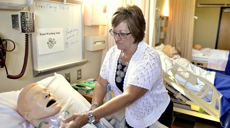 Clark State has received approval to offer an Associate of Applied Science degree in Health Sciences. This is professor Dala DeWitte a few years ago as she adjusts one of the treatment mannequins in one of the school’s nursing labs. Bill Lackey/Staff