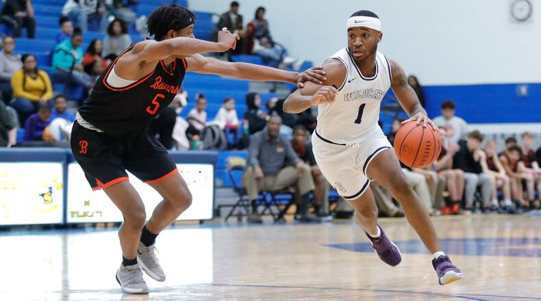Springfield High School senior Larry Stephens is guarded by Beavercreek’s Siloam Baldwin during their game on Tuesday night in Springfield. The Wildcats won 52-51. CONTRIBUTED PHOTO BY MICHAEL COOPER