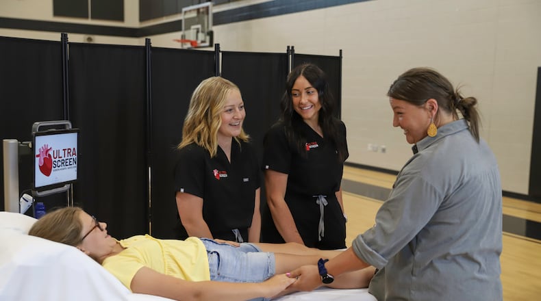 Registered cardiac sonographers Alyssa Souders (left) and Emma Beedy (right) perform cardiac screenings on a patient as part of their new business, Ultrascreen. Board-certified cardiologist Dr. Faiq Akhter (not pictured) will interpret the findings of the cardiac tests. ELIZABETH NEWMAN PHOTOGRAPHY/CONTRIBUTED