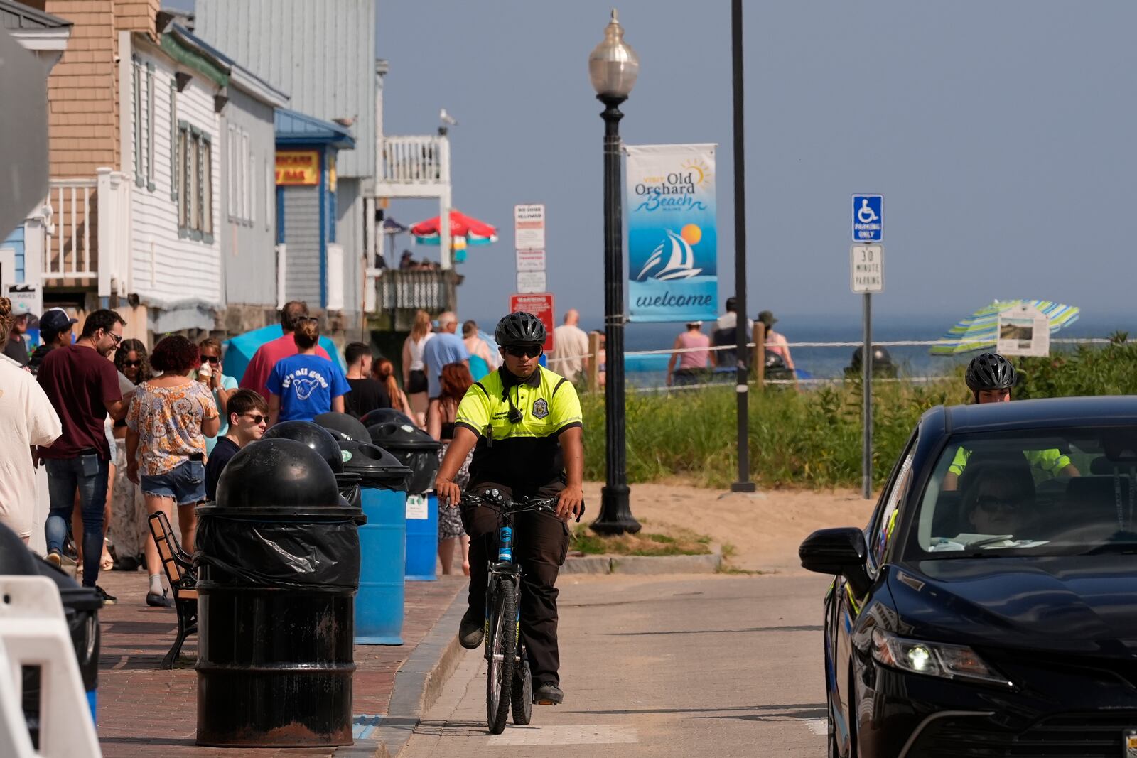 A Community Service Officer from the Old Orchard Beach Police Dept. patrols on a bicycle, Tuesday, July 29, 2025, in Old Orchard Beach, Maine. (AP Photo/Robert F. Bukaty)