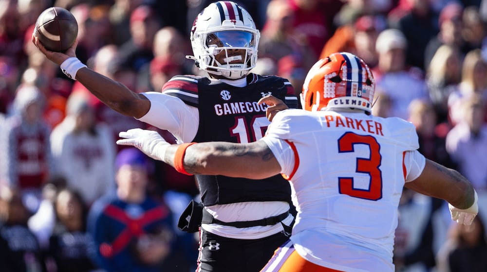 FILE - South Carolina quarterback Lanorris Sellers (16) throws under pressure from Clemson defensive end T.J. Parker (3) during the first half of an NCAA college football game, Nov. 29, 2025, in Columbia, S.C. (AP Photo/Scott Kinser, File)