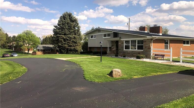 The 3-bedroom tri-level offers about 2,130 sq. ft. of living space with an updated kitchen and newer quartz-tile flooring. The front of the home features a circular asphalt driveway and brick-and-stone accents. There is also a covered front porch. CONTRIBUTED PHOTO