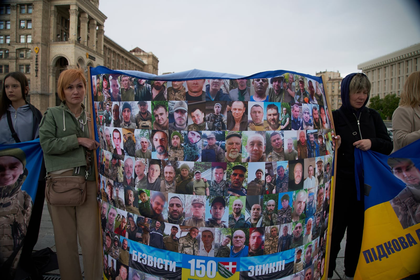 People with Ukrainian flags and banners attend a rally of families of missing soldiers from the Bakhmut garrison in Kyiv, Ukraine, Thursday, May 1, 2025. (AP Photo/Vasilisa Stepanenko)