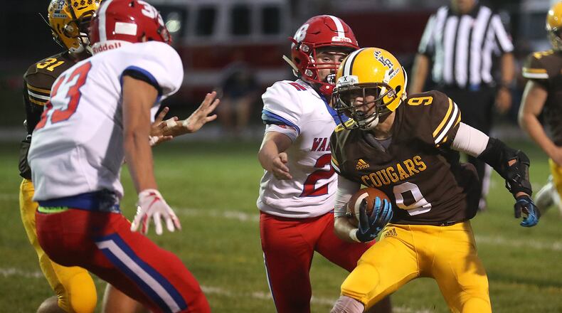 Kenton Ridge’s Drew Miller tries to avoid Northwestern’s Matthew Hart, left, and Devin Current. BILL LACKEY/STAFF