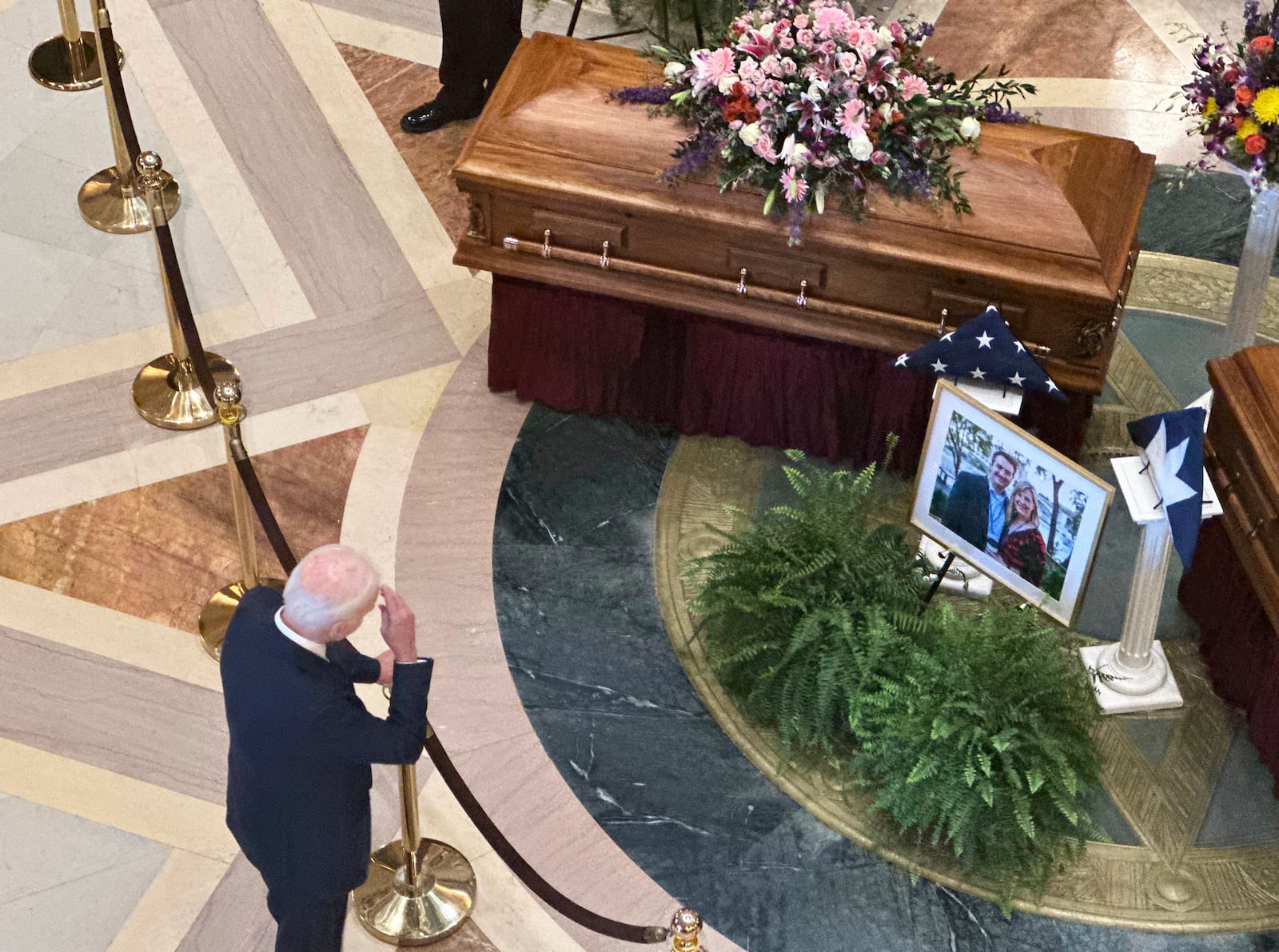 Former President Joe Biden makes a sign of the cross while paying his respects as former Minnesota House Speaker Melissa Hortman, her husband, Mark, and their golden retriever, Gilbert, lie in state in the Minnesota Capitol rotunda in St. Paul, Friday, June 27, 2025. (AP Photo/Steve Karnowski)