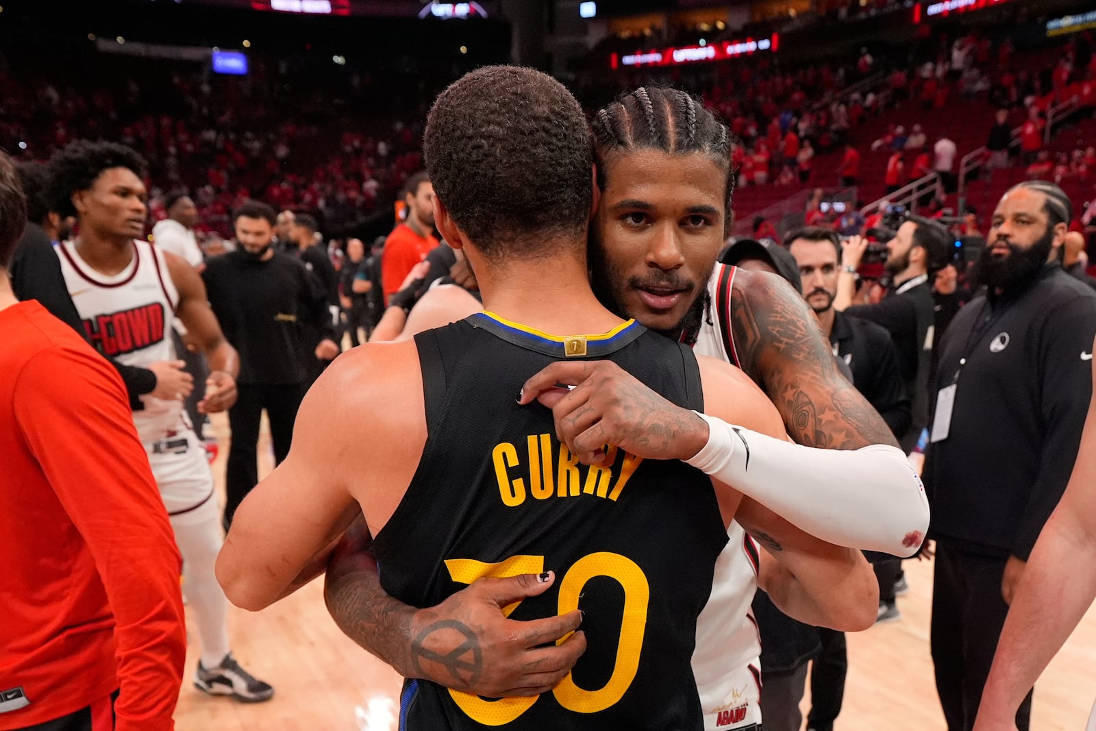Golden State Warriors' Stephen Curry (30) and Houston Rockets' Jalen Green hug after Game 7 of an NBA basketball first-round playoff series Sunday, May 4, 2025, in Houston. (AP Photo/Ashley Landis)