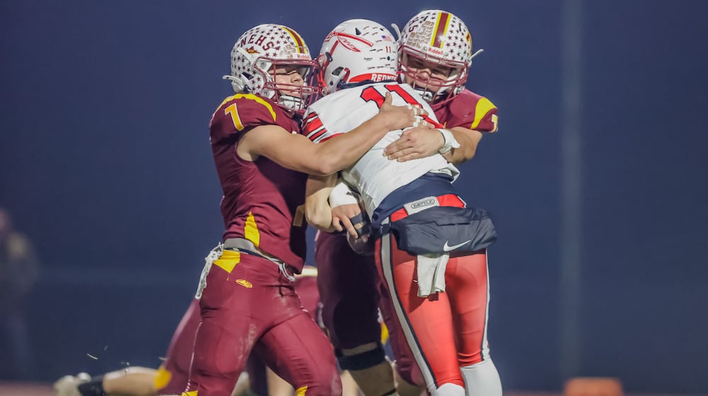 Northeastern High School seniors Jackson Jones and Steven Roddy tackle Ironton Rock Hill freshman quarterback Jarrod Bridges during their 59-0 victory in a Division VI, Region 24 quarterfinal game on Friday, Nov. 7 at Conover Stadium in Springfield. MICHAEL COOPER / STAFF PHOTO