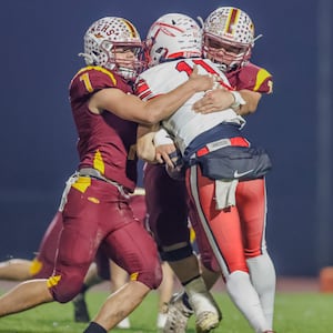 Northeastern High School seniors Jackson Jones and Steven Roddy tackle Ironton Rock Hill freshman quarterback Jarrod Bridges during their 59-0 victory in a Division VI, Region 24 quarterfinal game on Friday, Nov. 7 at Conover Stadium in Springfield. MICHAEL COOPER / STAFF PHOTO