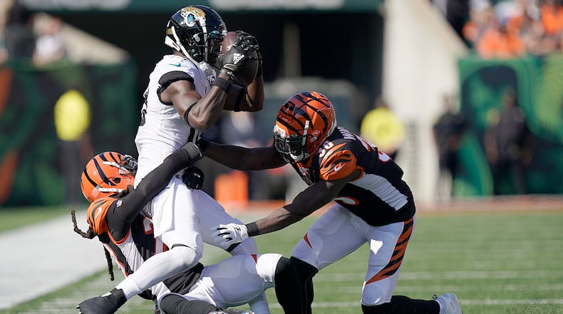 CINCINNATI, OHIO - OCTOBER 20: Chris Conley #18 of the Jacksonville Jaguars is tackled by Shawn Williams #36 and Torry McTyer #20 of the Cincinnati Bengals at Paul Brown Stadium on October 20, 2019 in Cincinnati, Ohio. (Photo by Bryan Woolston/Getty Images)