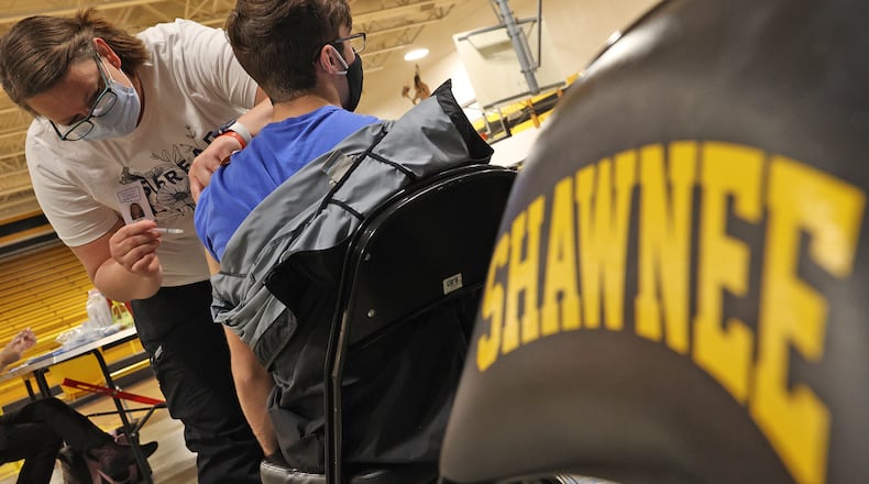 Nicole Wilson, a nurse at the Clark County Combined Health District, gives a student his COVID-19 vaccine injection during a vaccine clinic at Shawnee High School. BILL LACKEY / STAFF