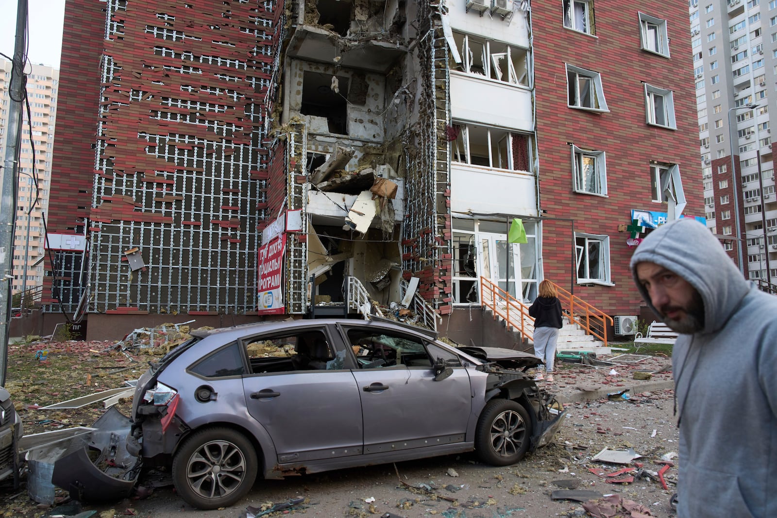 Residents react near their damaged multi-storey building damaged in Russia's missile and drone attack in Kyiv, Ukraine, Tuesday, June 10, 2025. (AP Photo/Efrem Lukatsky)