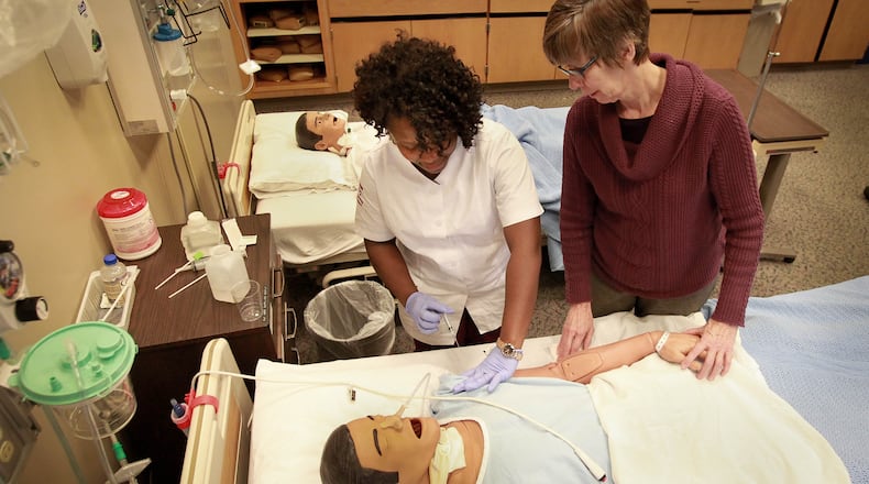 A professor works with a student in the Nursing Skills Lab at Sinclair Community College in 2015. The school could team up with UD to offer a path to a bachelor’s degree. STAFF