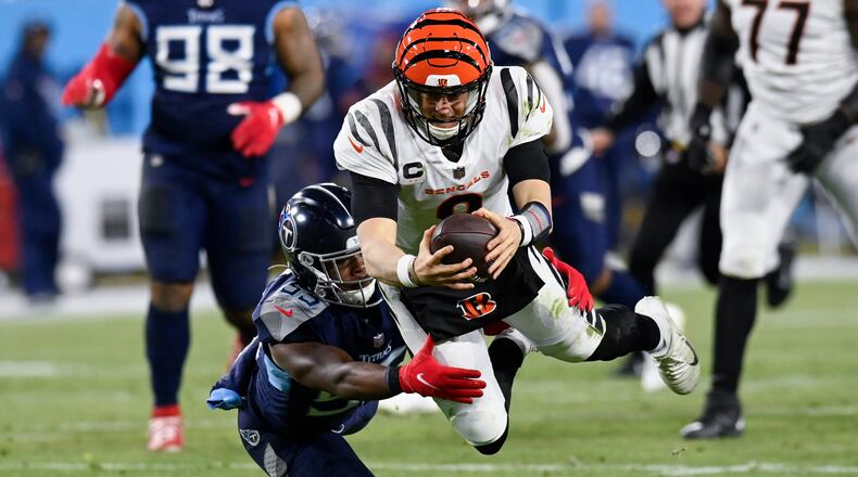 Cincinnati Bengals quarterback Joe Burrow (9) leaps for a first down against Tennessee Titans inside linebacker Jayon Brown (55) during the second half of an NFL divisional round playoff football game, Saturday, Jan. 22, 2022, in Nashville, Tenn. (AP Photo/Mark Zaleski)