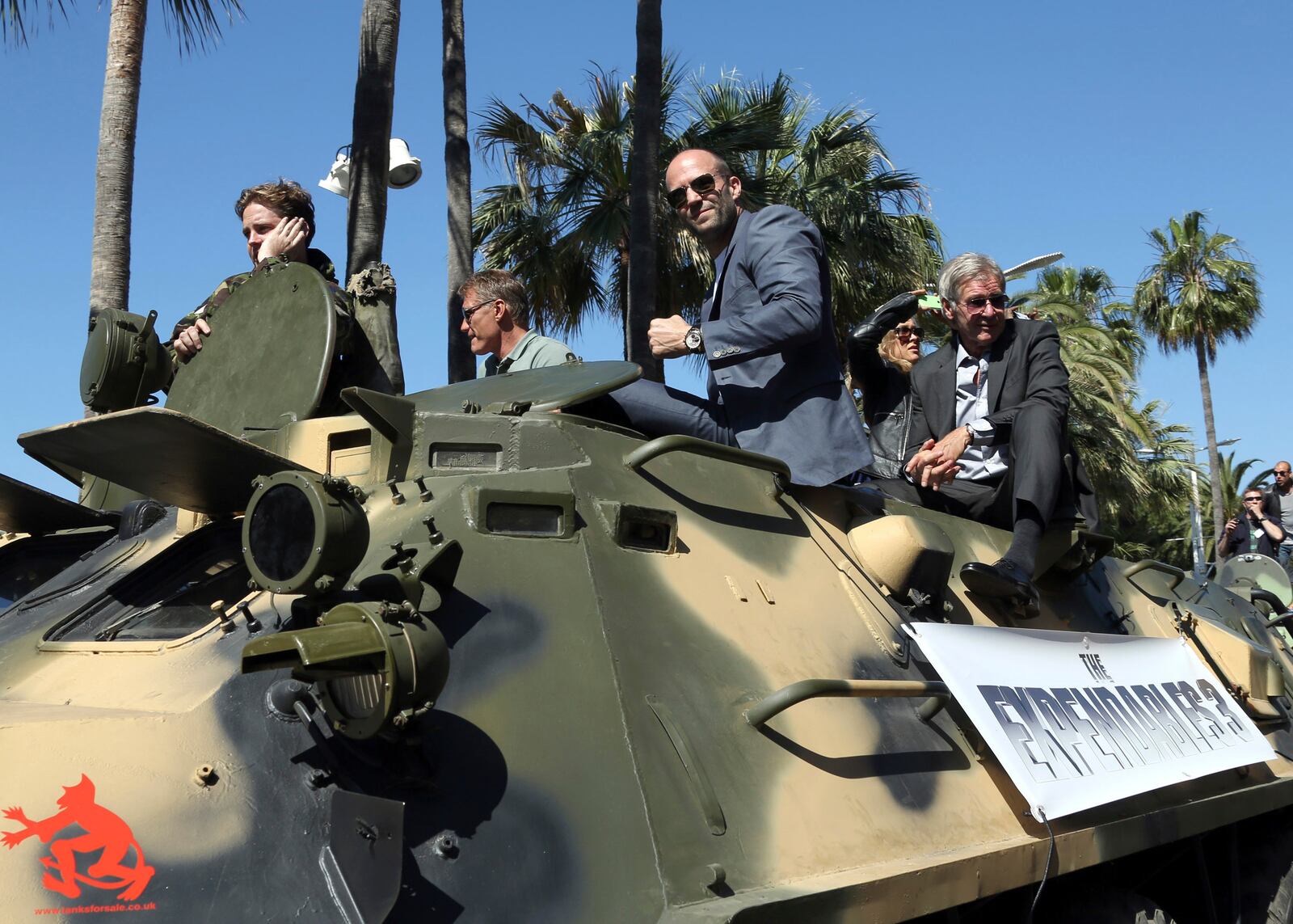FILE - Dolph Lundgren, from second left, Jason Statham, and Harrison Ford ride atop an armored vehicle during a photo call for The Expendables 3 at the 67th international film festival, Cannes, southern France, Sunday, May 18, 2014. (Photo by Joel Ryan/Invision/AP, File)
