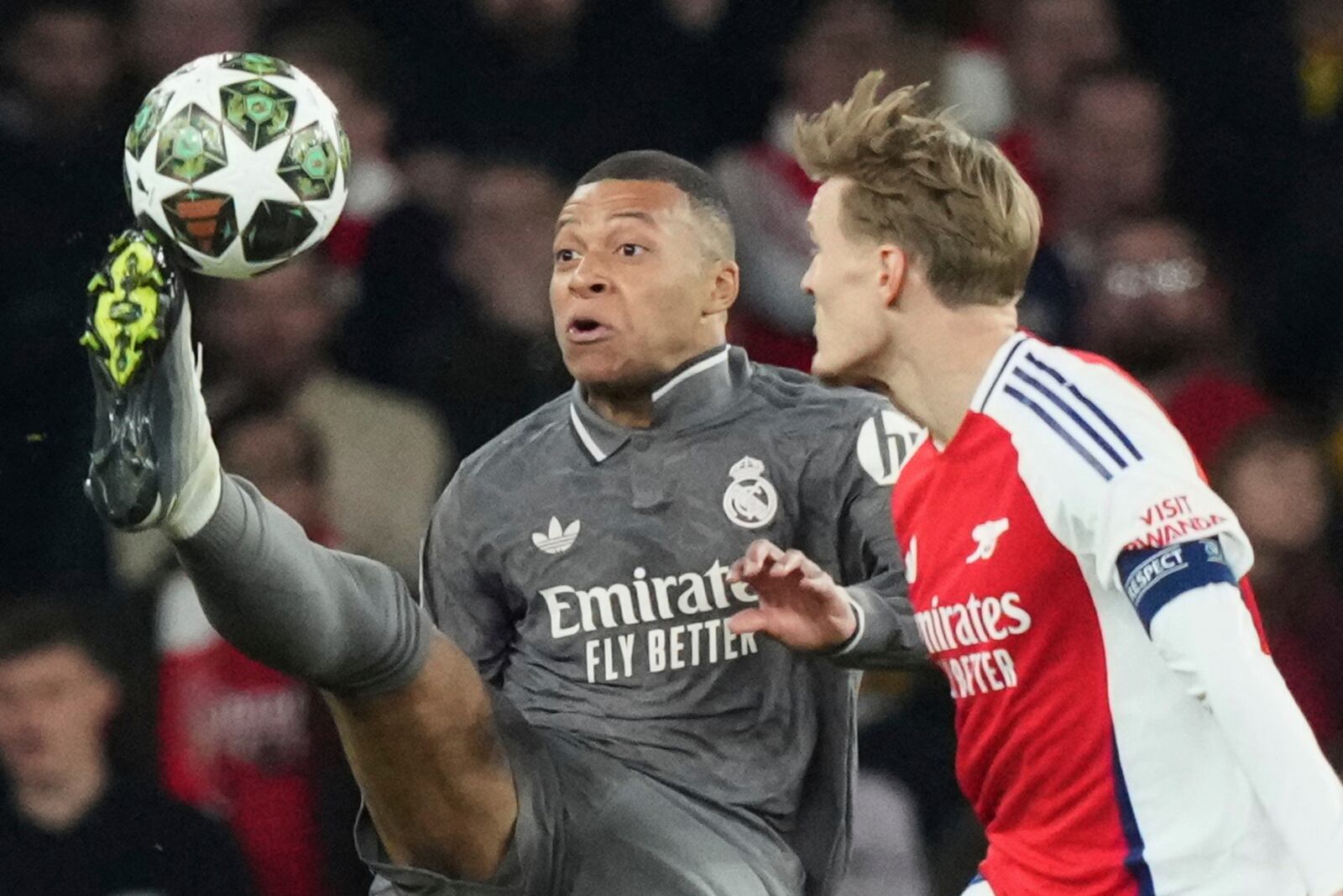 Real Madrid's Kylian Mbappe, left, controls the ball past Arsenal's Martin Odegaard during the Champions League quarterfinal first leg soccer match between Arsenal and Real Madrid at the Emirates Stadium in London, Tuesday, April 8, 2025. (AP Photo/Frank Augstein)