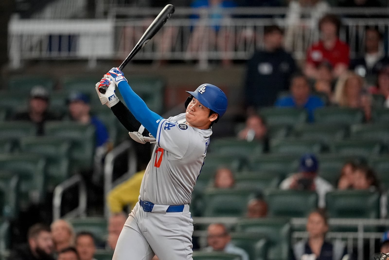 Los Angeles Dodgers two-way player Shohei Ohtani (17) hits a solo homer against the Atlanta Braves in the third inning of a baseball game, Saturday, May 3, 2025, in Atlanta. (AP Photo/Mike Stewart)