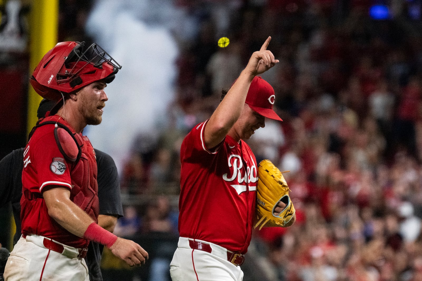 Cincinnati Reds catcher Tyler Stephenson, left, and pitcher Emilio Pagán, right, walk off the field together after winning a baseball game against the Chicago Cubs, Saturday, Sept. 20, 2025, in Cincinnati. (AP Photo/Michael Swensen)