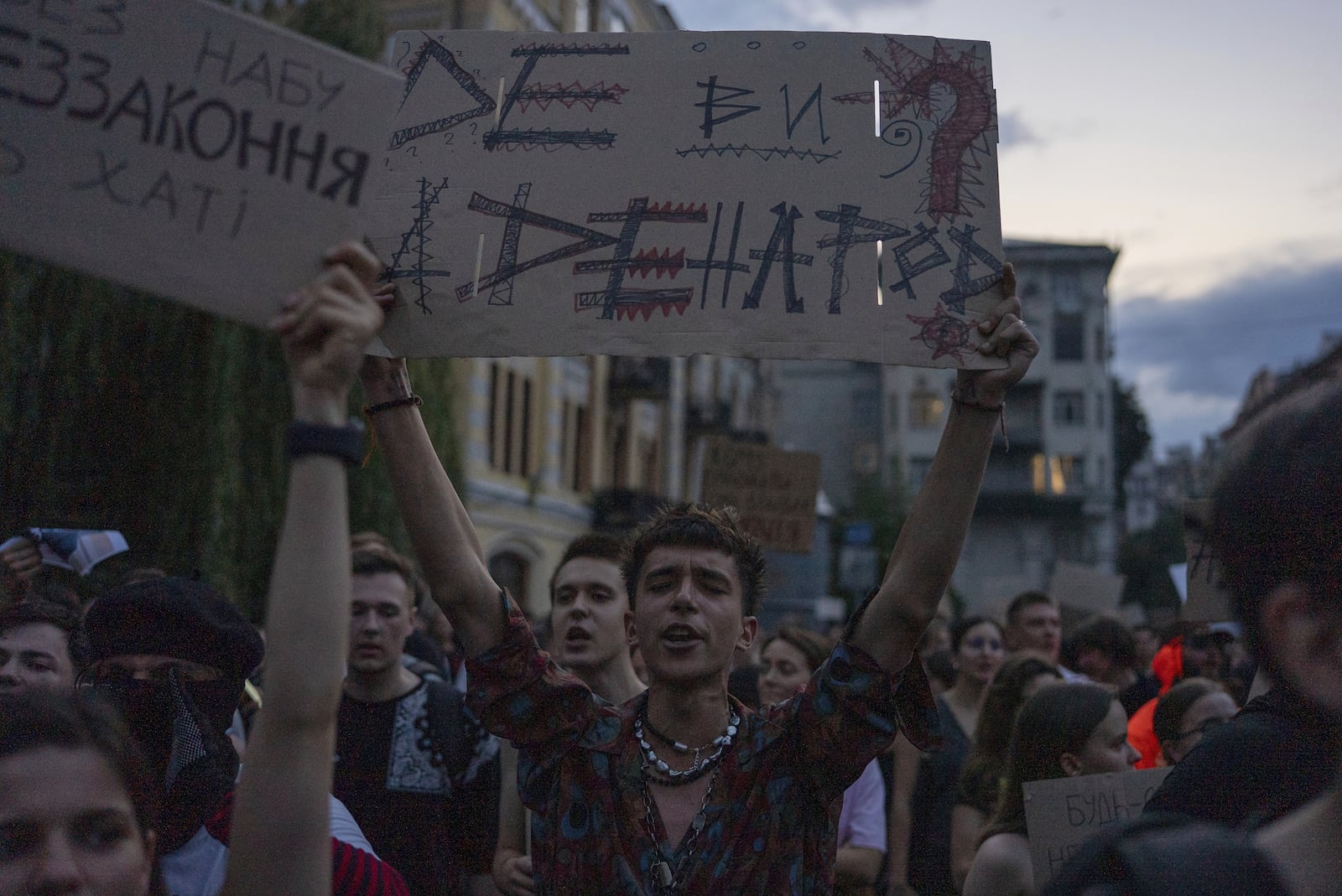 Man chants and holds banner reading "Where are you and where are the people?" during a protest against a law targeting anti-corruption institutions in central Kyiv, Ukraine, Tuesday, July 22, 2025. (AP Photo/Alex Babenko)