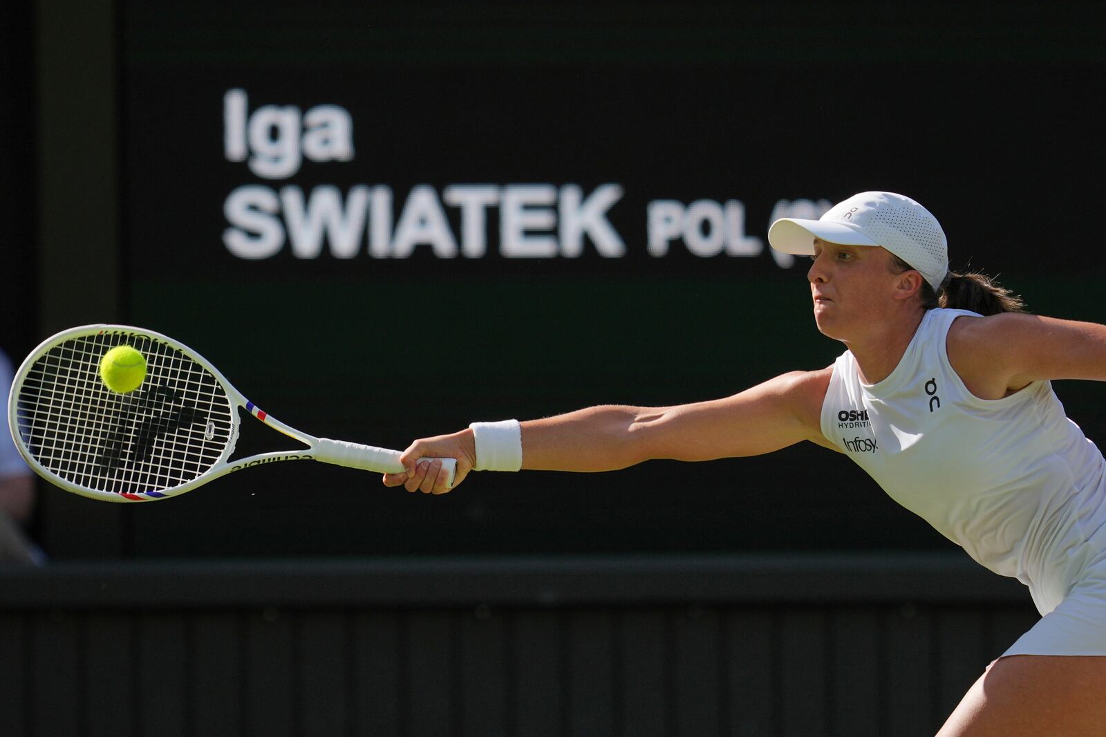 Poland's Iga Swiatek returns to Switzerland's Belinda Bencic during a women's singles semifinal match at the Wimbledon Tennis Championships in London, Thursday, July 10, 2025. (AP Photo/Kin Cheung)