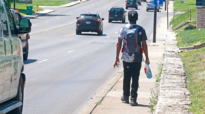 A pedestrian walks on a narrow sidewalk along North Limestone Avenue on Wednesday, May 31, 2023. A proposed transportation plan would widen the sidewalk here and add a mid-block crosswalk to reduce pedestrian-car crashes. BILL LACKEY/STAFF