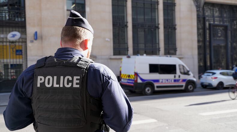 Police stand outside the Bank of America building in Paris, Saturday, March 28, 2026. (AP Photo/Nicolas Garriga)