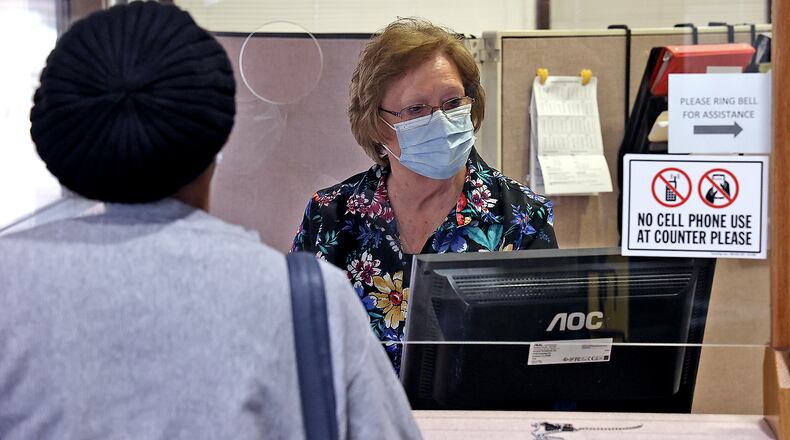 Winona Fink, a City of Springfield employee, waits on a resident at the Income Tax window in the lobby of the Springfield City Hall Thursday. The city may be receiving millions of dollars in federal relief money as part of a new stimulus bill. BILL LACKEY/STAFF