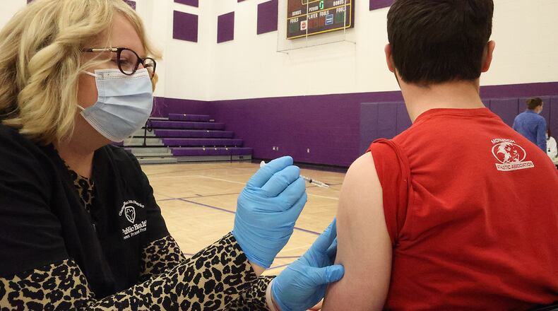 Student Alden Prohaska gets the COVID vaccine from Hope Stickley, a nurse from the Champaign County Health Department, on during a COVID clinic in one of Mechanicsburg High School's gymnasiums Thursday, April 22, 2021. More school and community clinics are scheduled in Clark and Champaign counties today and Friday. BILL LACKEY/STAFF