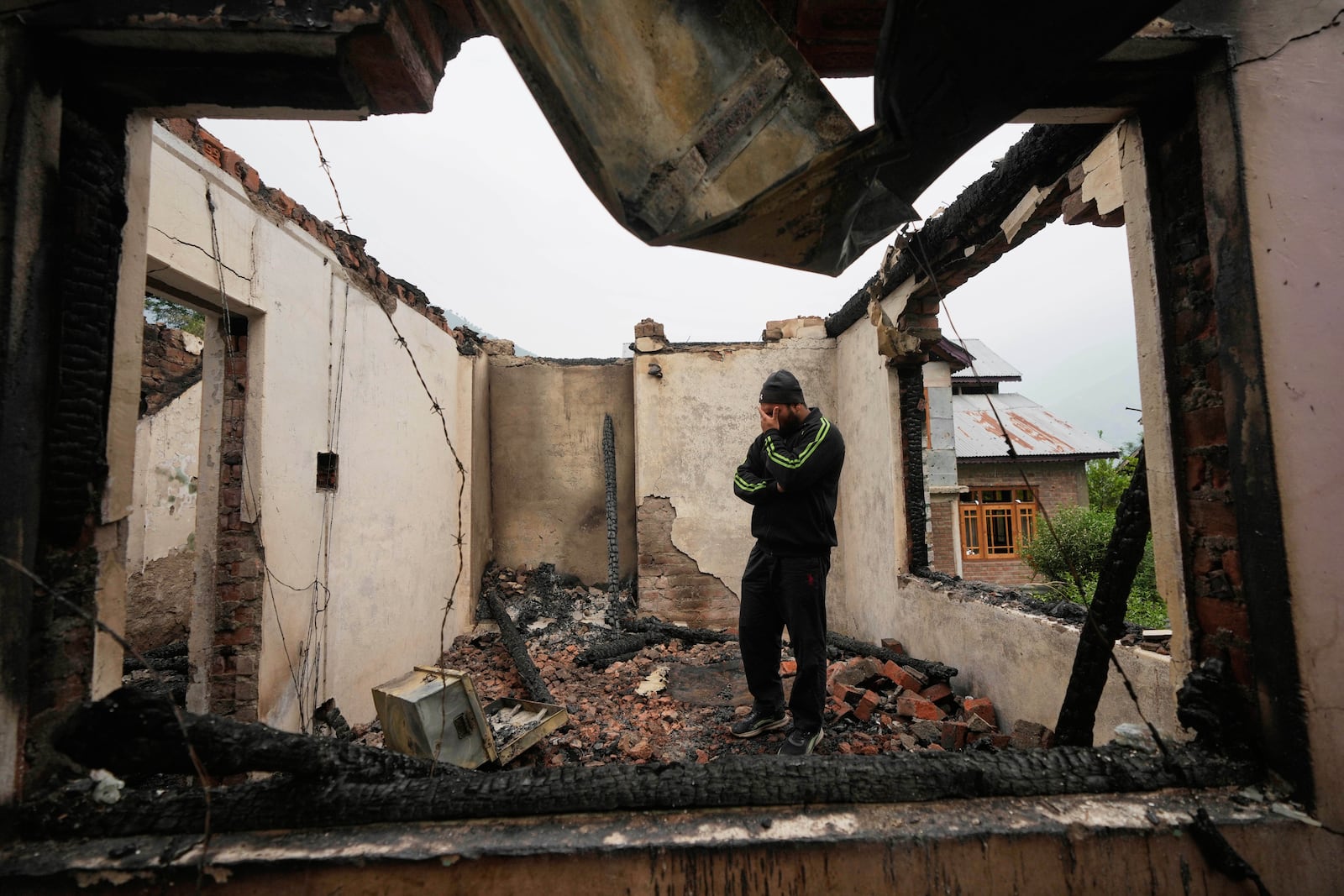 Mohammad Sahil reacts as he stands inside his house damaged by Pakistani artillery shelling, at Salamabad village in Uri, north of Srinagar, Indian controlled Kashmir, Thursday, May 8, 2025. (AP Photo/Mukhtar Khan)