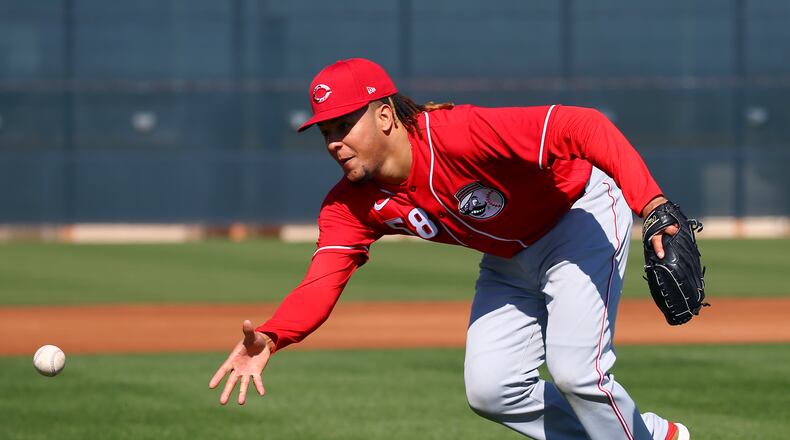 Cincinnati Reds starting pitcher Luis Castillo flips the ball to home plate during spring training baseball workouts Monday, Feb. 17, 2020, in Goodyear, Ariz. (AP Photo/Ross D. Franklin)