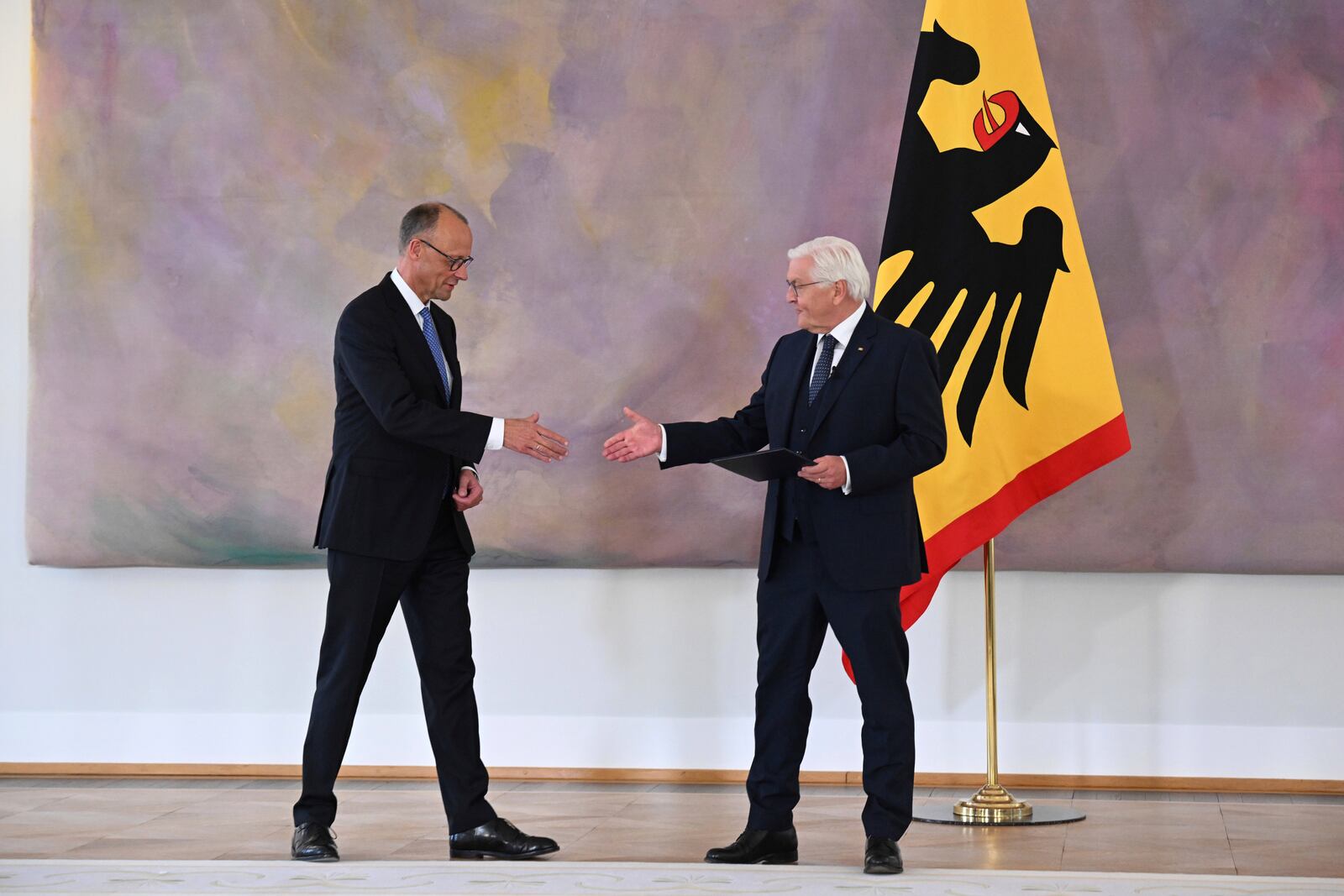 German President Frank-Walter Steinmeier, right, presents Federal Chancellor Friedrich Merz with his certificate of appointment at Bellevue Palace in Berlin, following his election by the German Bundestag, on Tuesday May 6, 2025. (Bernd von Jutrczenka/dpa via AP)