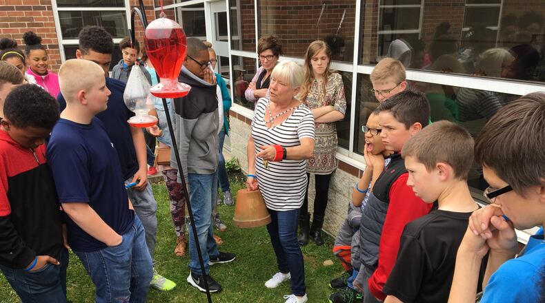 Sixth-grade teacher Connie Jensen shows students where a time capsule containing letters to their future selves will be sealed and opened upon the students’ senior year of high school as part of a project in the school’s courtyard. Contributed by Brett Turner
