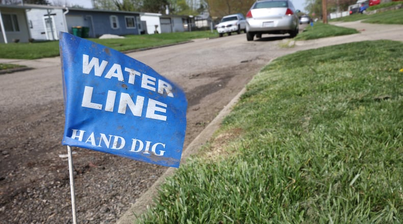 Blue flags line Fenwick Drive in New Carlisle Wednesday. Clark County is submitting a community development block grant in hopes of repairing the flooding problems with the road. BILL LACKEY/STAFF