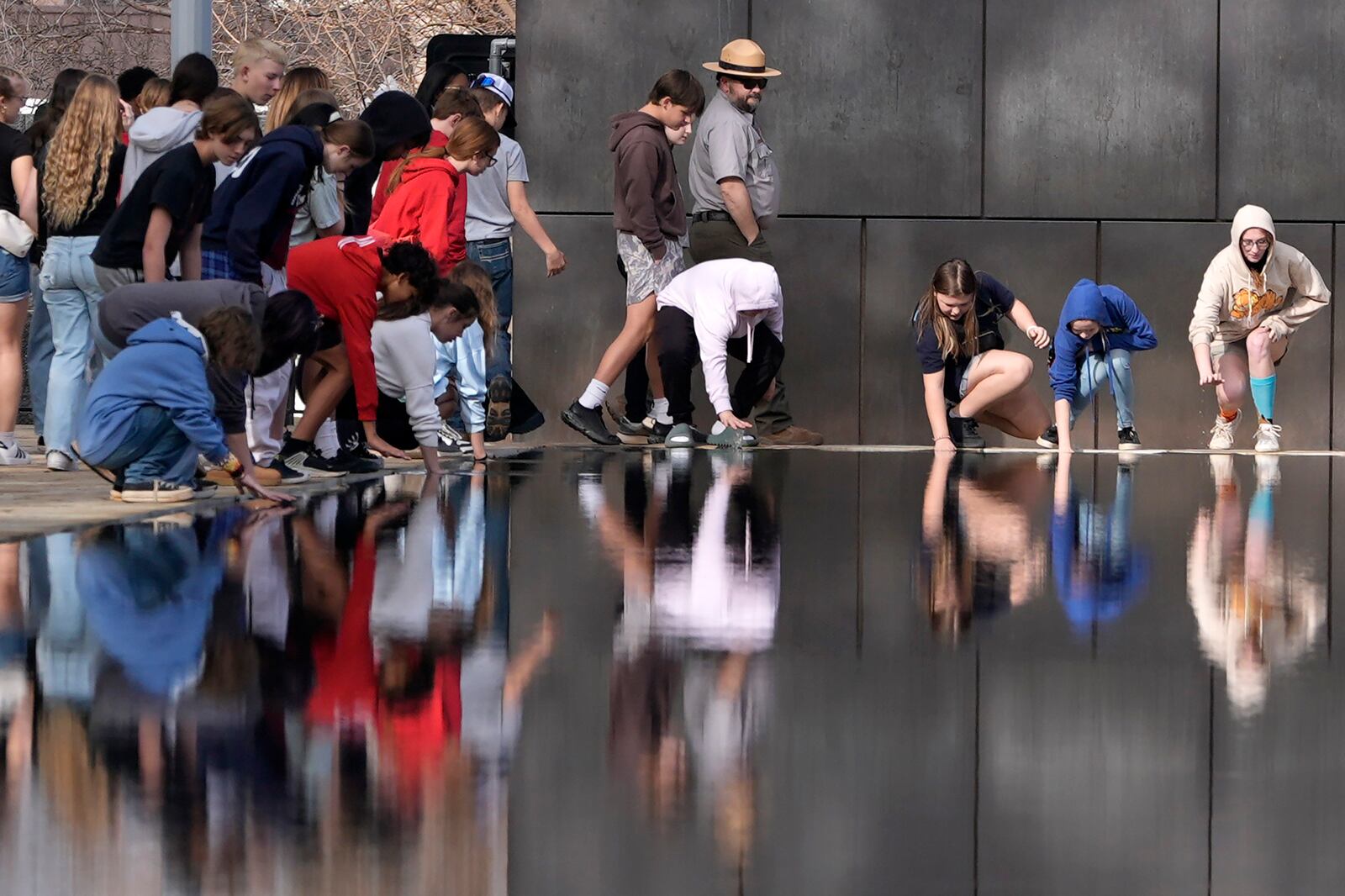Visitors touch the Reacting Pond at the Oklahoma City National Memorial & Museum in Oklahoma City on March 12, 2025. (AP Photo/LM Otero)