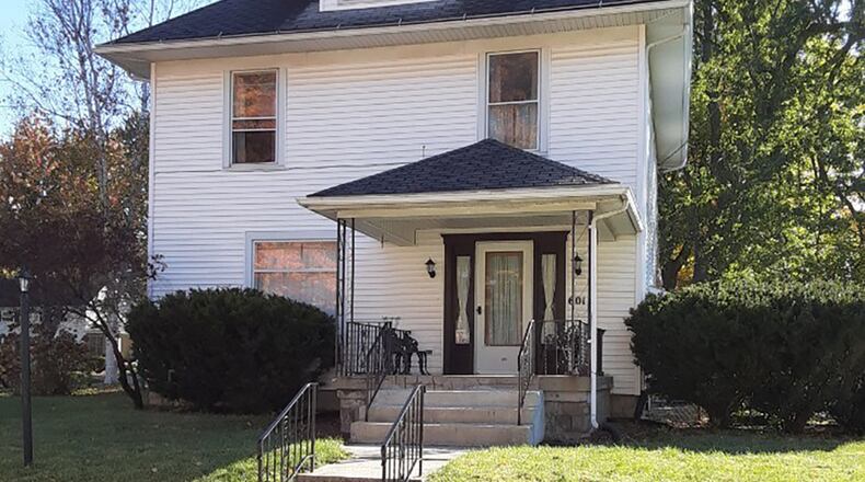 The 2-story home with 4 bedrooms has about 1,850 sq. ft. of living space, plus a semi-finished basement and a third-floor walk-up attic. An ornate front door with matching side panels open from the covered porch directly into the living room. CONTRIBUTED PHOTO
