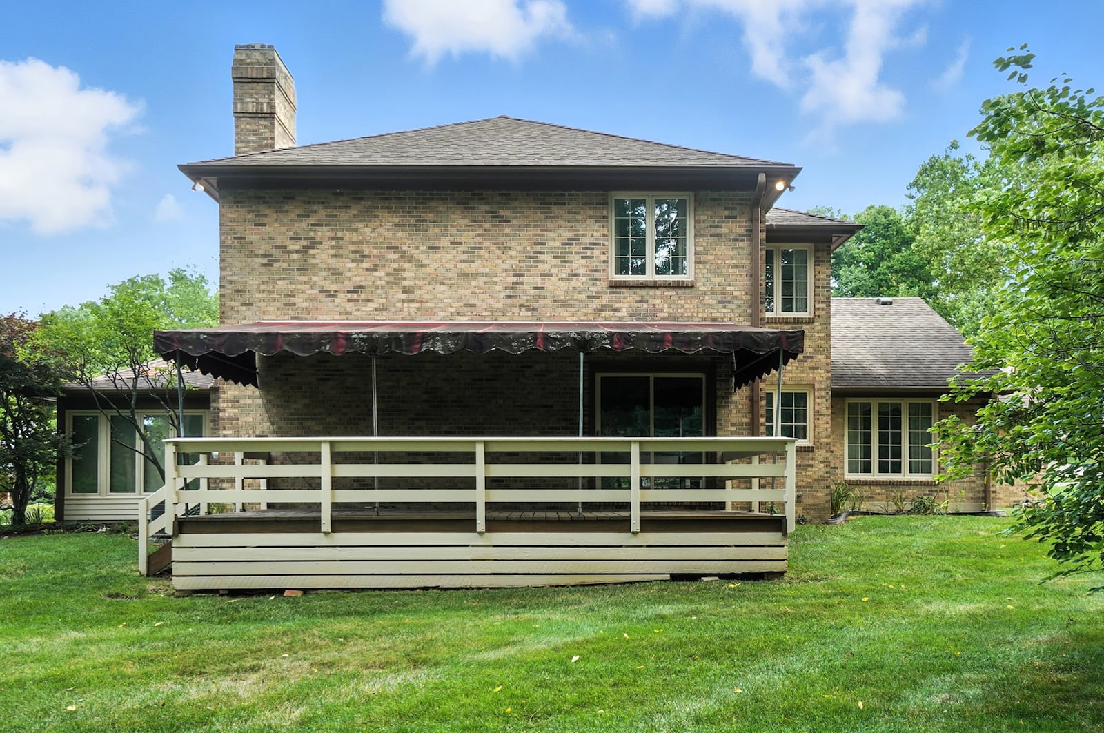 The back of the home features a wood deck with railings covered by an awning. CONTRIBUTED