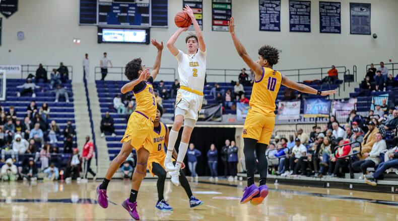 Centerville High School senior Eli Greenberg shoots the ball while being guarded by two Reynoldsburg defenders during their game on Sunday night at The Beacon Orthopaedics Flyin’ to the Hoop Invitational at Trent Arena in Kettering. MICHAEL COOPER/CONTRIBUTED