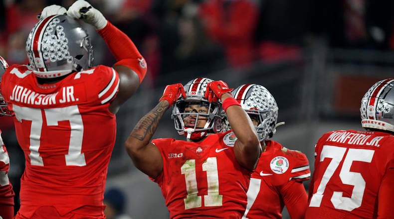 FILE - Ohio State wide receiver Jaxon Smith-Njigba (11) celebrates his touchdown catch with offensive lineman Paris Johnson Jr. (77) during the second half in the Rose Bowl NCAA college football game against Utah on Jan. 1, 2022, in Pasadena, Calif. Smith-Njigba, the starting slot receiver for the Buckeyes as a sophomore last year, stepped out of the shadow of the more established receivers to pace the Buckeyes with 95 catches and 1,606 yards. (AP Photo/John McCoy, File)