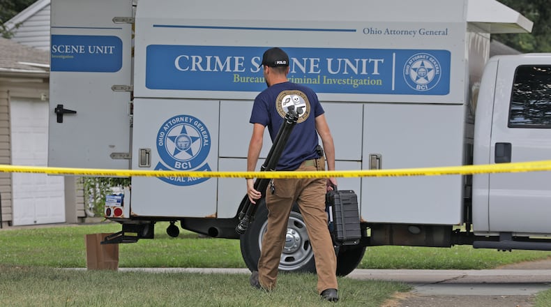 An Investigator from the Bureau of Criminal Investigation carries equipment into a house at 141 Weinland Street last year. BILL LACKEY/STAFF
