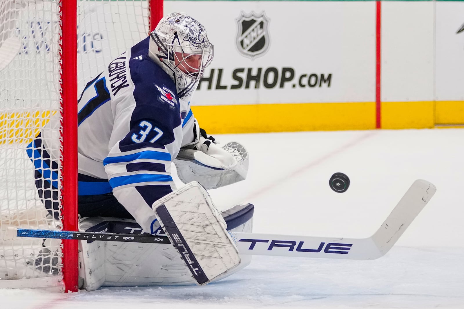 FILE - Winnipeg Jets goaltender Connor Hellebuyck blocks a shot by the Dallas Stars during the first period of an NHL hockey game April 10, 2025, in Dallas. (AP Photo/Julio Cortez, File)