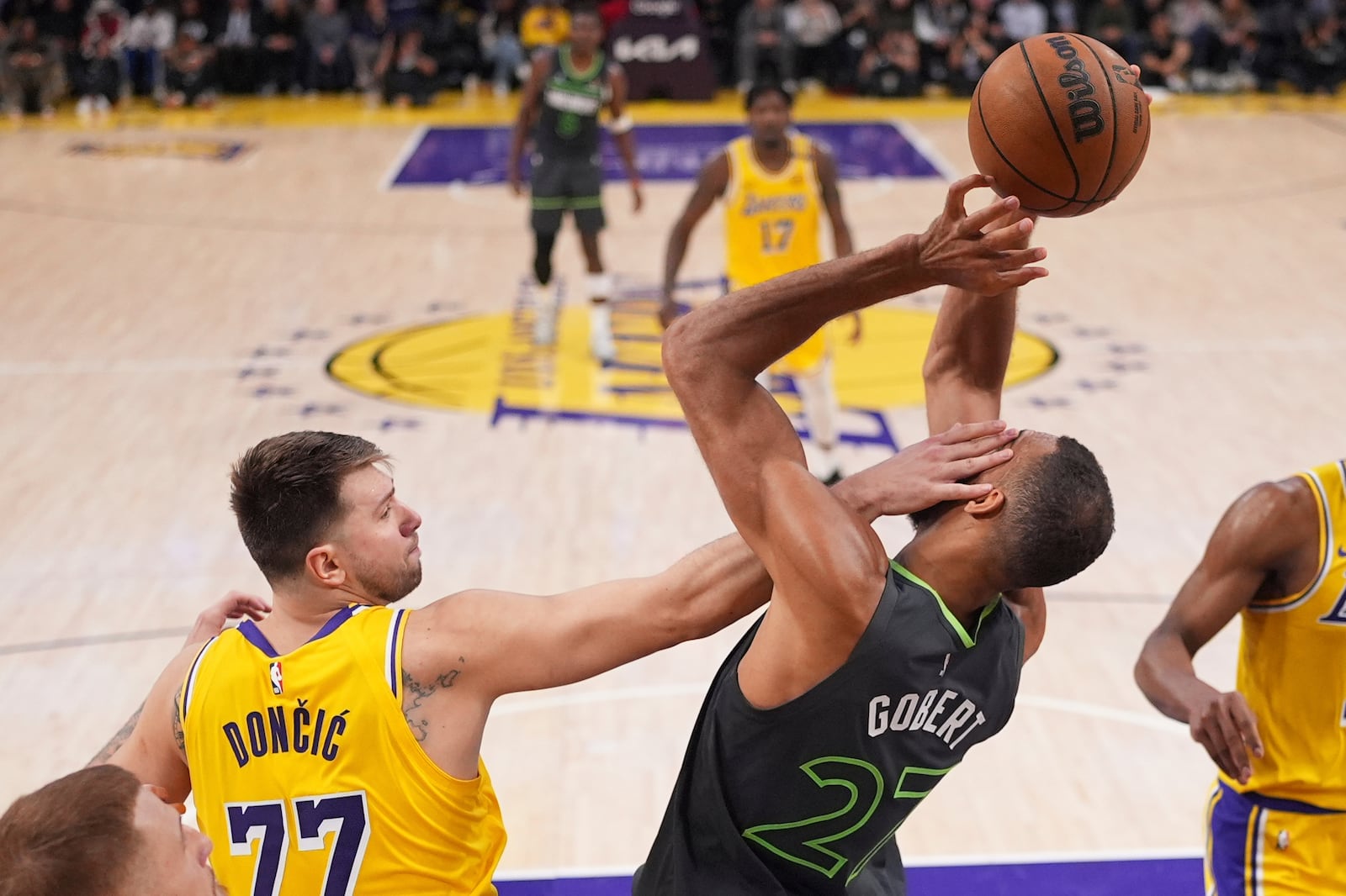 Minnesota Timberwolves center Rudy Gobert, right, is hit in the face by Los Angeles Lakers guard Luka Doncic as he grabs a rebound during the first half in Game 5 of an NBA basketball first-round playoff series Wednesday, April 30, 2025, in Los Angeles. (AP Photo/Mark J. Terrill)