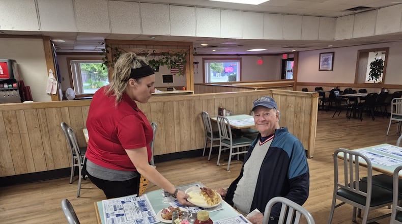 Christina Lauderman serves Jack Norris his breakfast Wednesday at the nearly empty Fairborn Family Diner near Wright Patterson Air Force Base. They said that since the government shutdown, business has taken a noticeable hit. MICHAEL KURTZ / STAFF